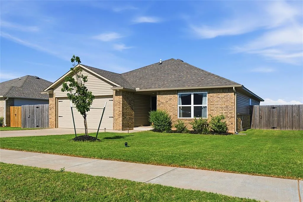 The brick exterior, front lawn, and garage of a real Sam’s Place home