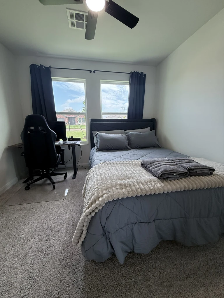 A private Sam’s Place bedroom with a dedicated desk, monitor and office chair