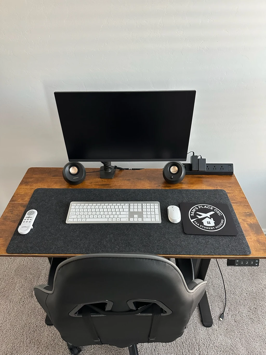 Standing desk with monitor, keyboard, mouse, and office chair