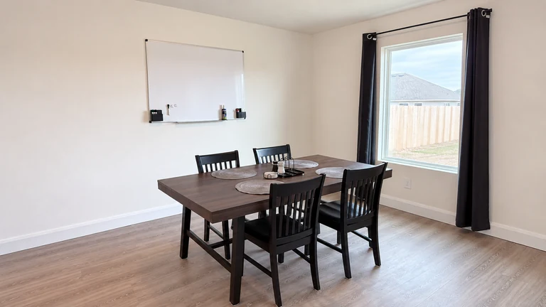 A shared dining and study table with a whiteboard in a Sam’s Place home