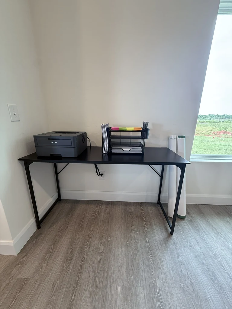 Shared work table with a printer and Academy study supplies